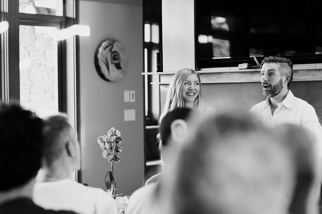 A couples workshop in black and white, a woman smiling as Travis speaks